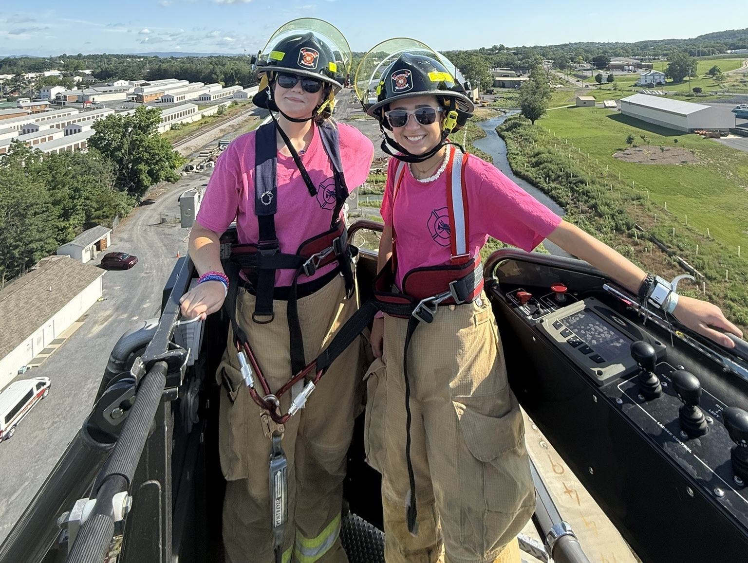 Two campers smiling in the fire ladder truck.