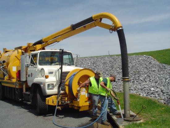 Crews operate a flush truck to clean storm drains.