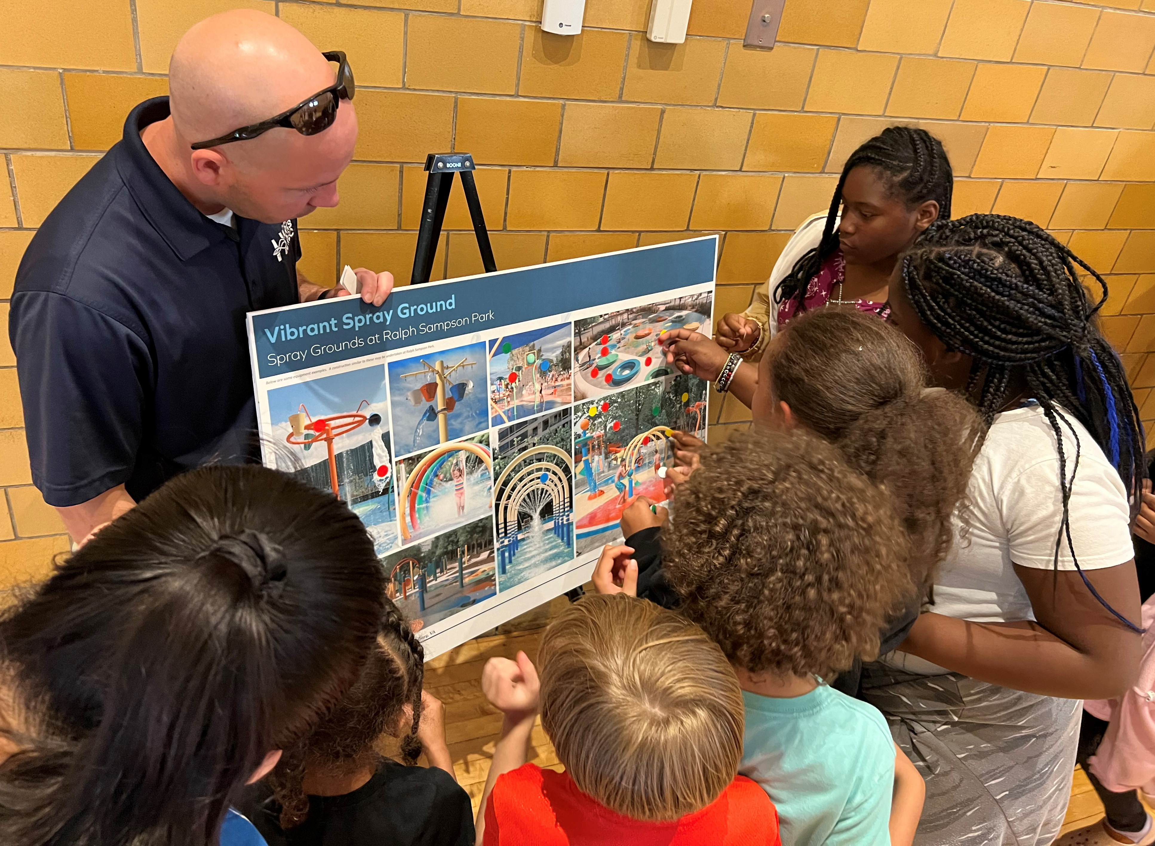 A Parks & Recreation staff members attends a past public engagement meeting to talk with community members about a future amenity.