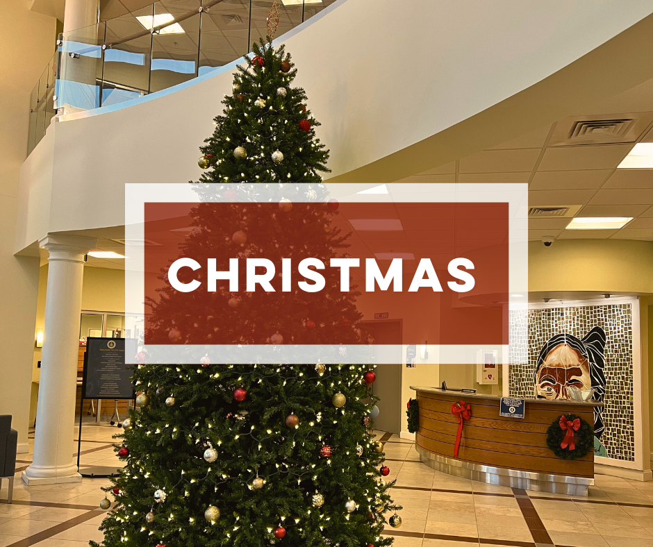 Decorated Christmas tree in the lobby of City Hall with bold text Christmas.