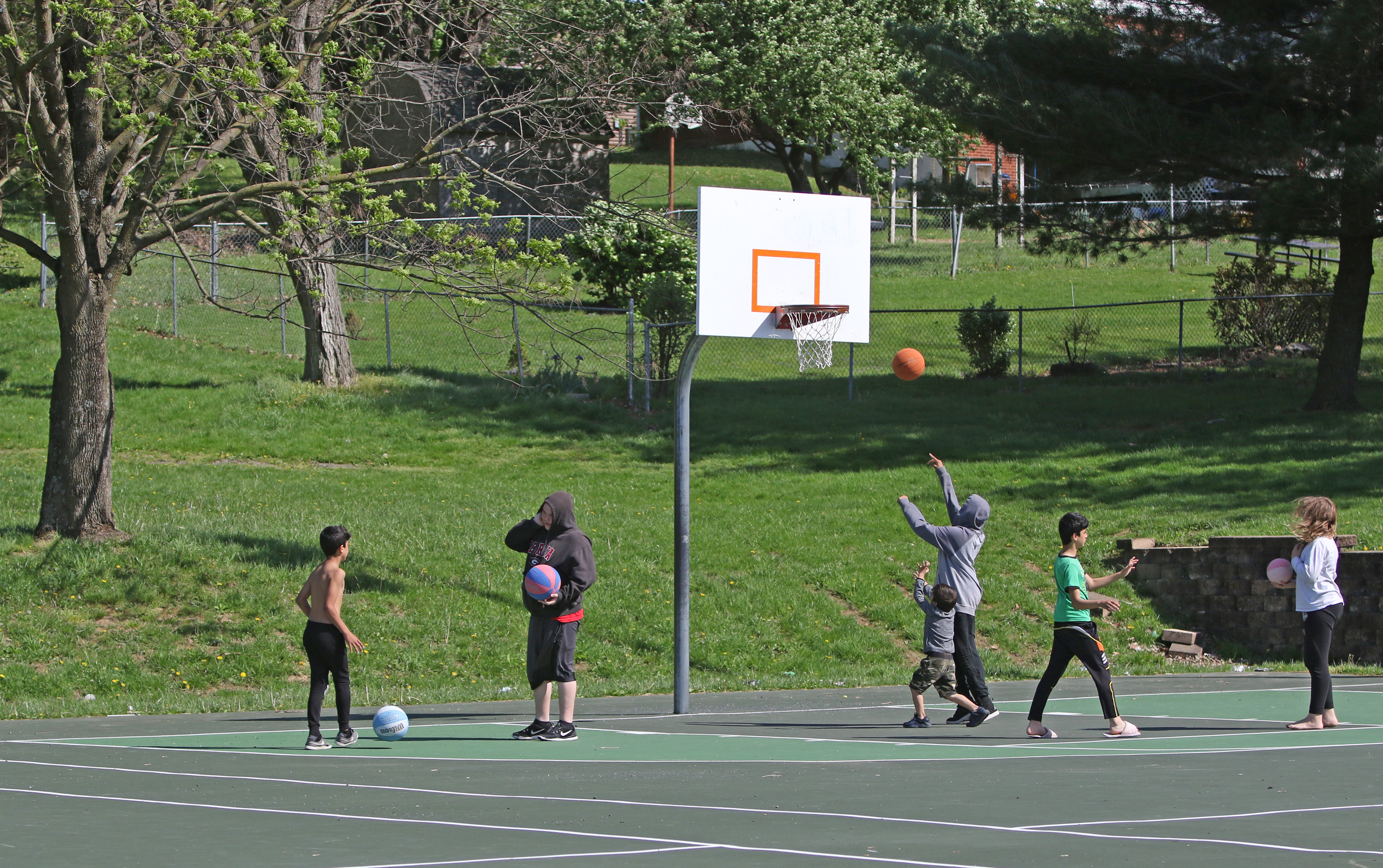 Image of children palying a game of basketball at the outdoor court in Ralph Sampson Park