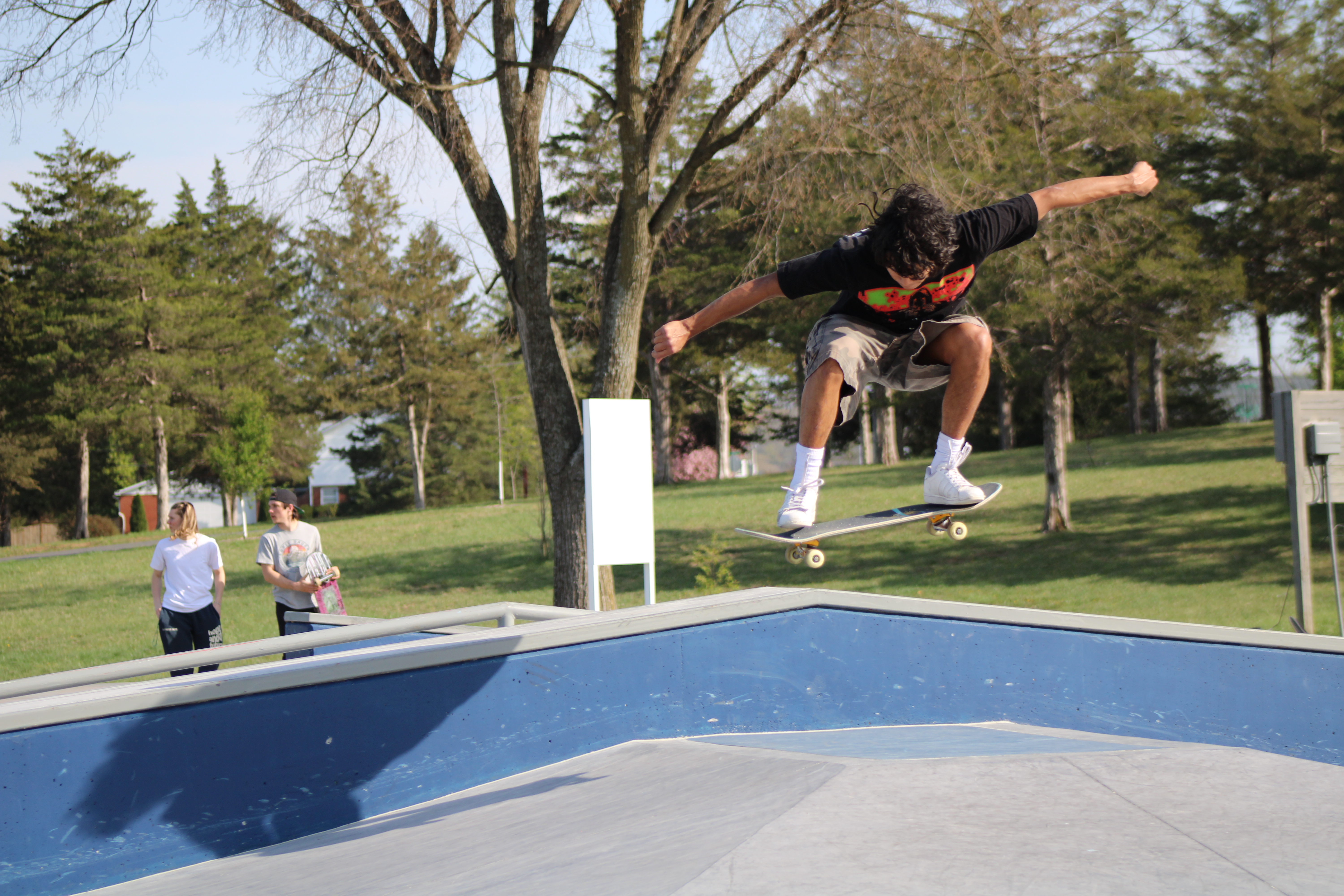 man jumping a skateboard on to a hubba at the skate park.