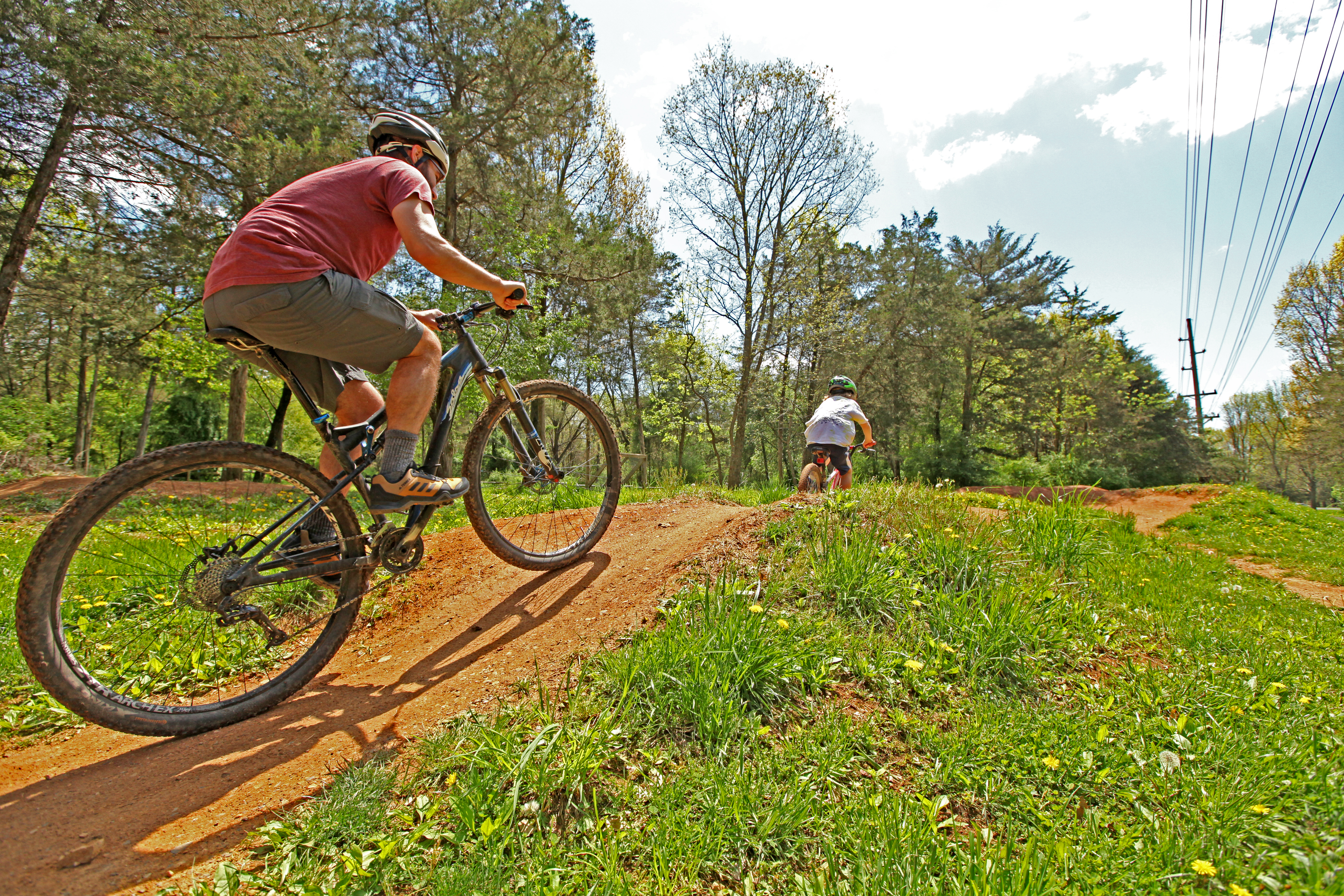 Image of two people riding bikes down South Ave Powerline Trail. Part of the Rocktown Trails system.  